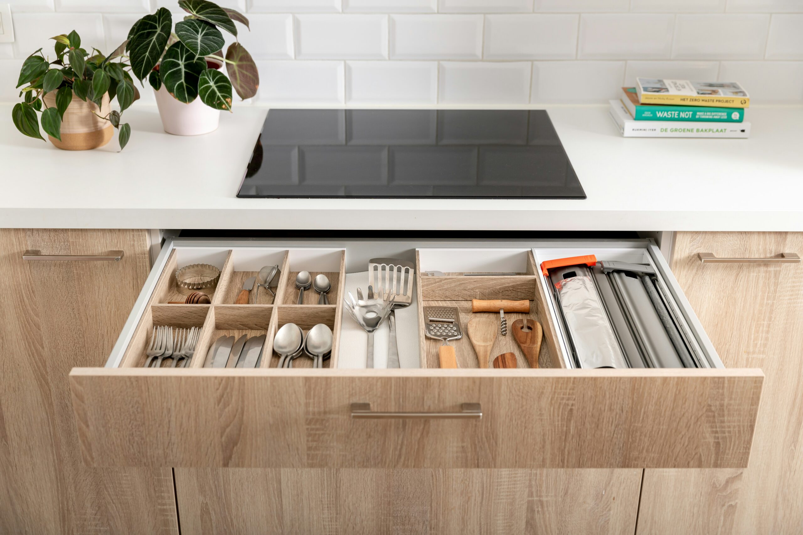 Kitchen drawer organizer with divided compartments for cutlery, utensils, and food storage essentials.